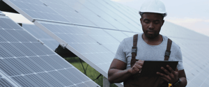 Building-worker-looking-at-digital-tablet-in-front-of-solar-panels