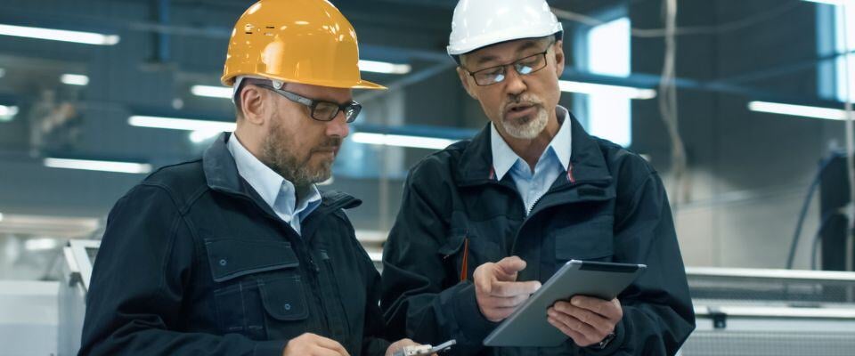 Building-workers-talking-looking-at-digital-tablet