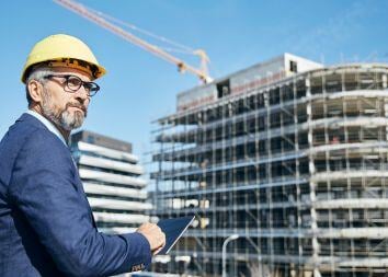 Facility-management-professional-using-digital-tablet-next-to-building