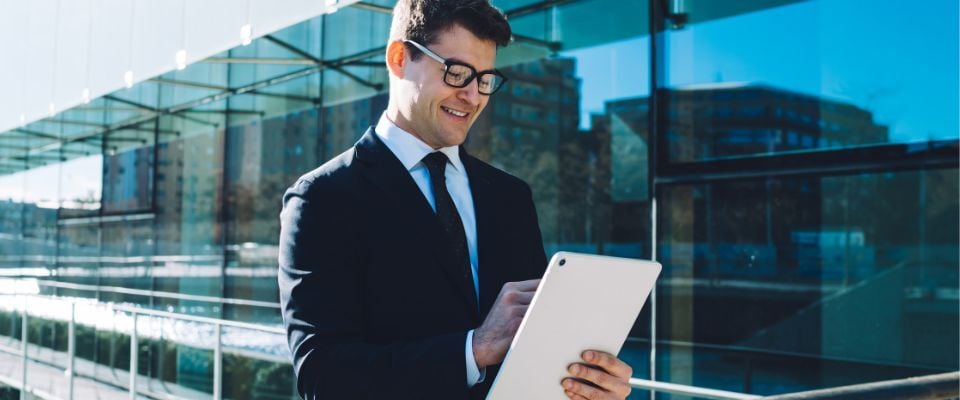 Man-using-digital-tablet-in-front-of-glass-building