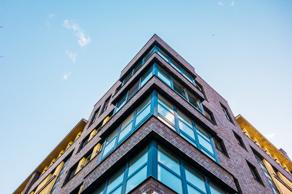 brick-building-rising-toward-blue-sky-above-2026-09-24-17-53-39-utc