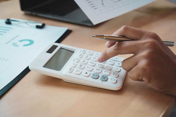 hand-using-calculator-with-financial-documents-nea-2026-09-22-03-18-44-utc