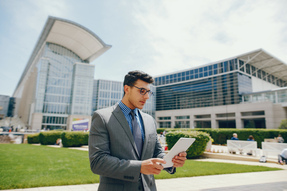 man-in-suit-reads-tablet-near-convention-center-2026-09-21-08-08-04-utc
