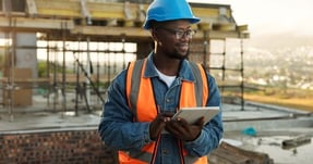 smiling-construction-worker-holding-tablet-at-buil-2026-09-25-07-05-29-utc