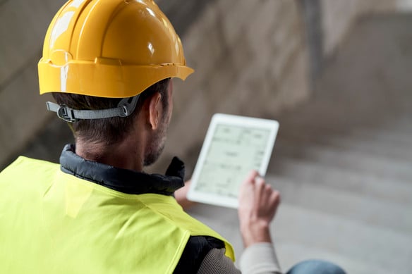 worker-examines-digital-tablet-wearing-yellow-hard-2026-09-22-22-22-19-utc