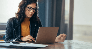 Woman In Office Using Laptop