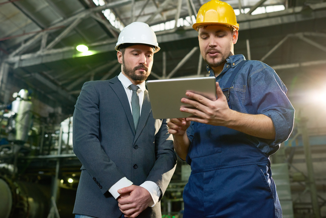 businessmen-in-hard-hats-reviewing-tablet-in-facto-2026-09-21-23-27-35-utc